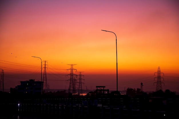 High Voltage electric pylons with colorful landscapes after sunset