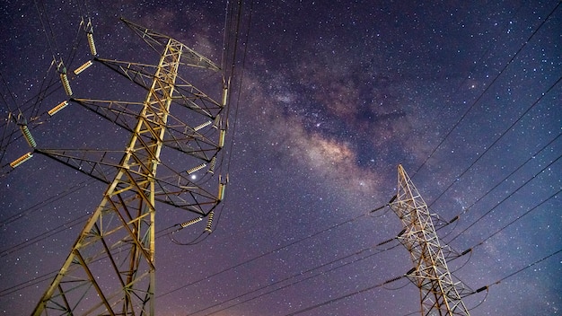 Photo high voltage electric tower on milky way sky background.