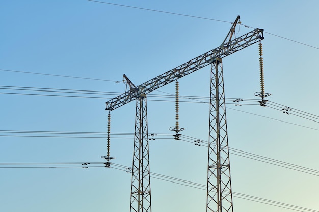 High voltage electricity tower with power line against blue sky Overhead electric power line with insulators Electricity generation transmission and distribution network Indastry landscape