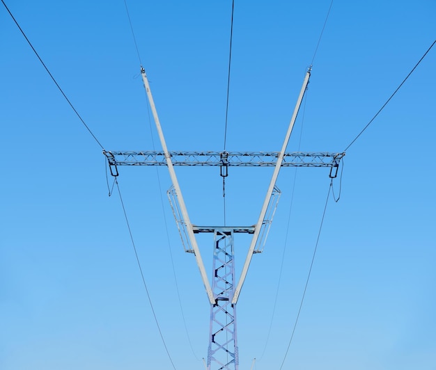 High voltage electricity tower with power line against blue sky Overhead electric power line with insulators Electricity generation transmission and distribution network Indastry landscape