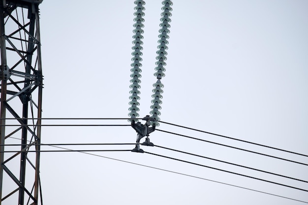 High voltage insulation string on steel pillar with electric power lines for safe delivering of electrical energy through cable wires on long distance