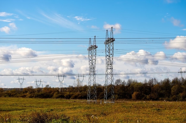 High voltage lines and power pylons in agricultural landscape on a sunny day with beautiful clouds in the blue sky