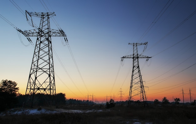 High-voltage power lines during fiery sunrise