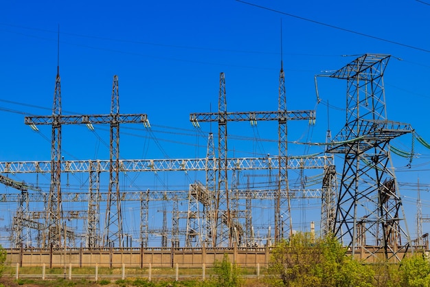 High voltage power lines towers on blue sky background