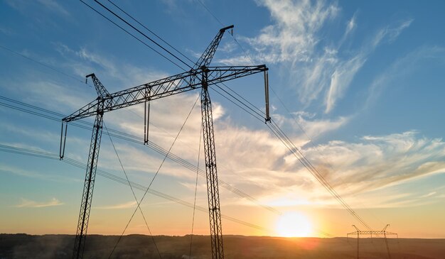 High voltage tower with electric power lines at sunset Transmission of electricity