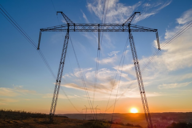 High voltage tower with electric power lines at sunset Transmission of electricity