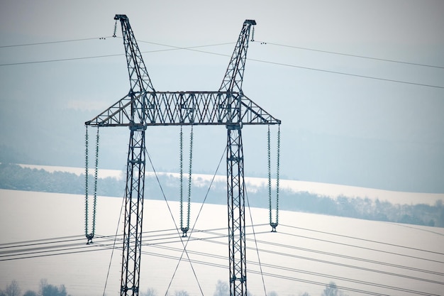 High voltage tower with electric power lines transfening electrical energy through cable wires