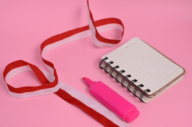 Highlighter blank notebook and ribbon on pink background Indonesian independence concept