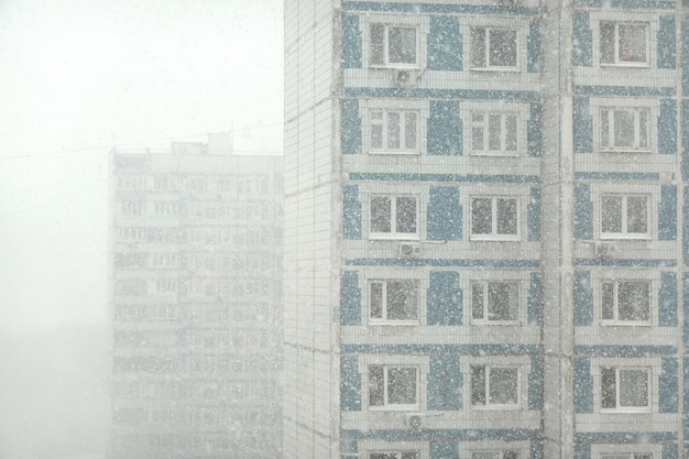 Highrise apartment blocks in a residential area of the city on a cloudy day in a snowfall