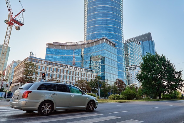 Highrise crane builds skyscraper in administrative center of warsaw warsaw city street traffic busin