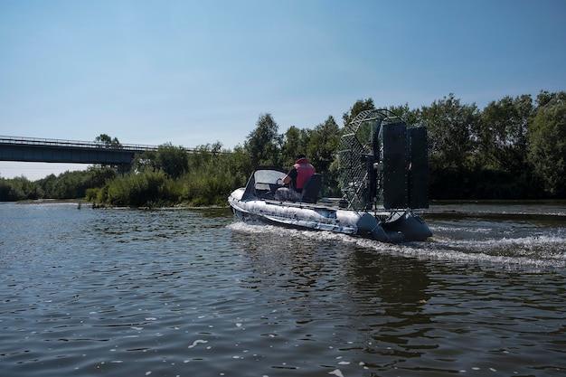 Highspeed riding in an airboat on the river on a summer day with splashes and waves