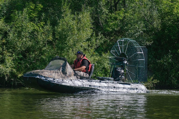 Highspeed riding in an airboat on the river on a summer day with splashes and waves