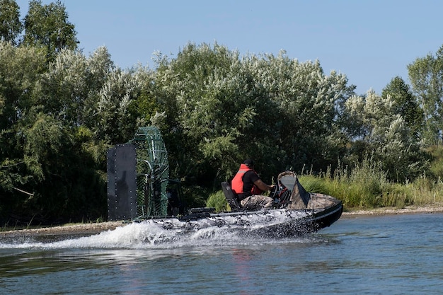 Highspeed riding in an airboat on the river on a summer day with splashes and waves