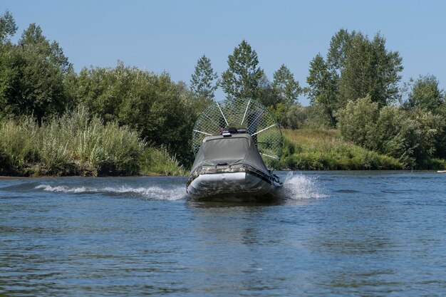 Highspeed riding in an airboat on the river on a summer day with splashes and waves