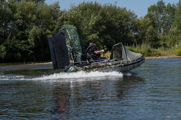 Highspeed riding in an airboat on the river on a summer day with splashes and waves