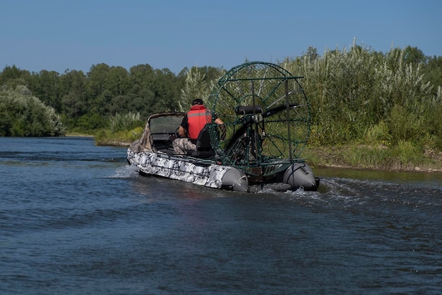 Highspeed riding in an airboat on the river on a summer day with splashes and waves