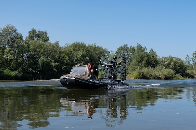 Highspeed riding in an airboat on the river on a summer day with splashes and waves