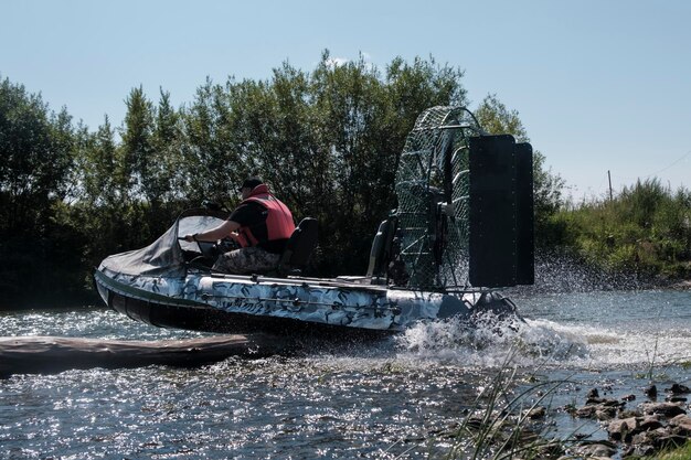 Highspeed riding in an airboat on the river on a summer day with splashes and waves