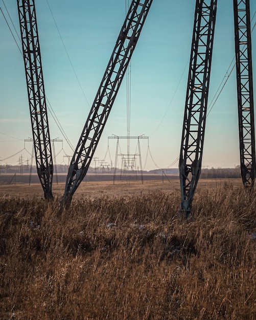 Highvoltage power lines poles at sunset in the field high voltage electric transmission tower