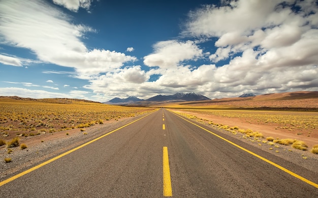 Highway road, sand and volcano in Atacama desert in Chile, South America