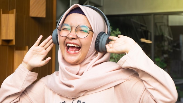 Hijab woman listens to music through headphones