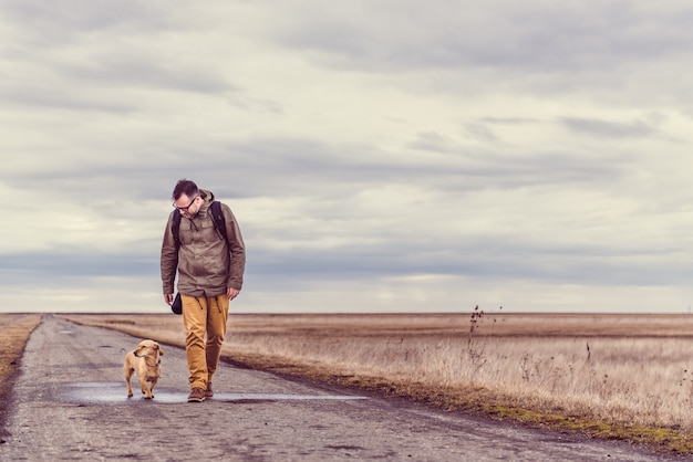 Hiker and dog walking on the road