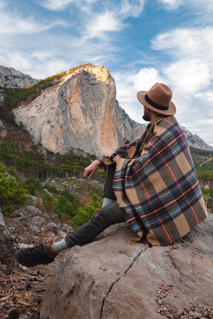 Hiker enjoying landscape with mountains, forest and sky. Mountaineering and Traveling.