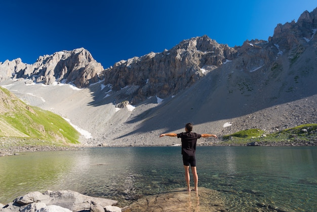 Hiker relaxing at high altitude blue lake in idyllic uncontaminated environment Summer adventures on the Alps. 