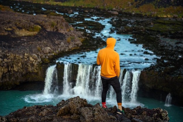 Hiker standing at the edge of the thjofafoss waterfall in iceland