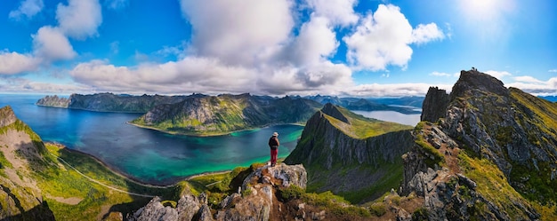 Hiker standing on the top of husfjellet mountain on senja island in norway