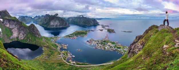 Hiker on top of Mt Reinebringen Lofoten islands Norway