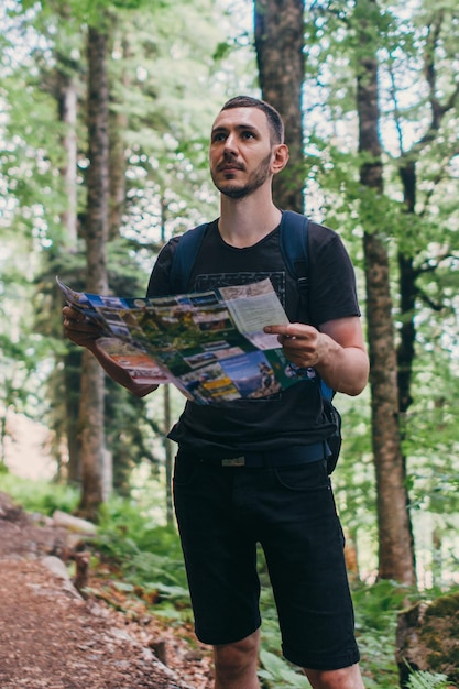 Hiker using a map to locate the destination in forest