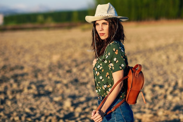 Hiker young woman hiking in the countryside at sunset