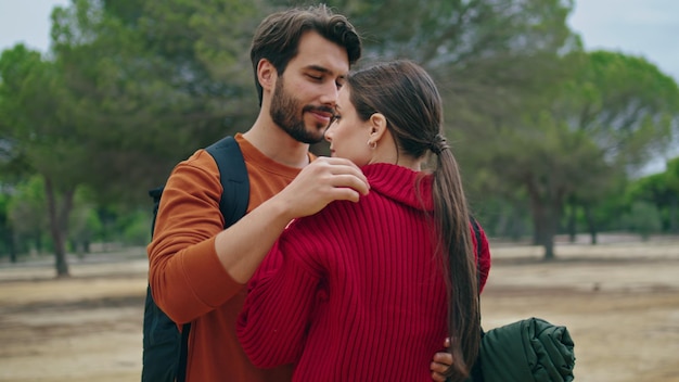 Hikers hugging standing nature with backpacks close up couple in love embracing