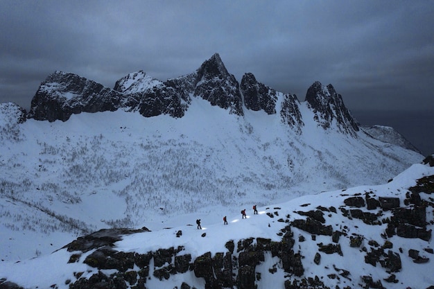 Hikers walking up Segla mountain during the blue hour