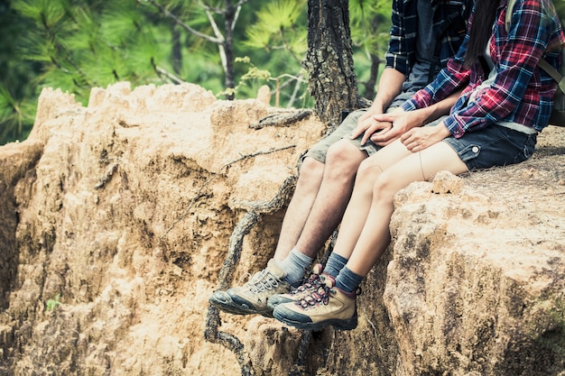 Hikers with backpacks relaxing on top of a hill, freedom and active lifestyle concept