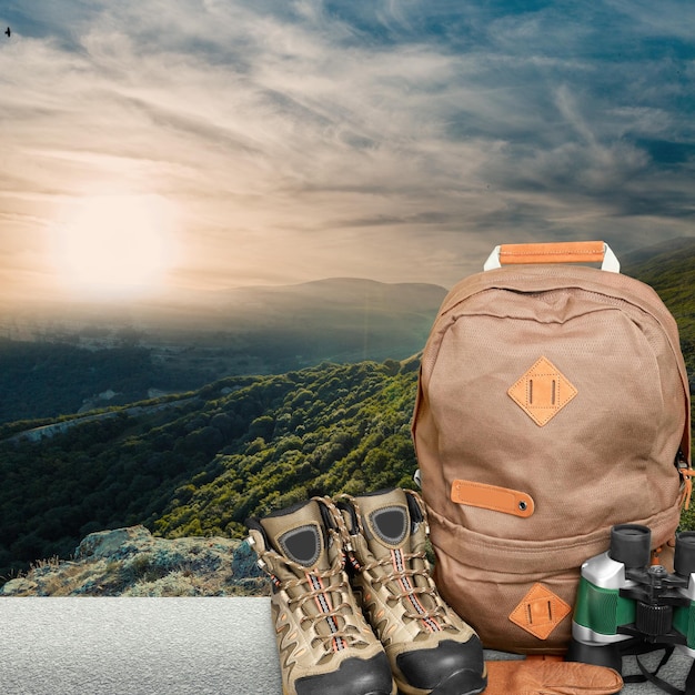 Hiking boots, compass and backpack on background