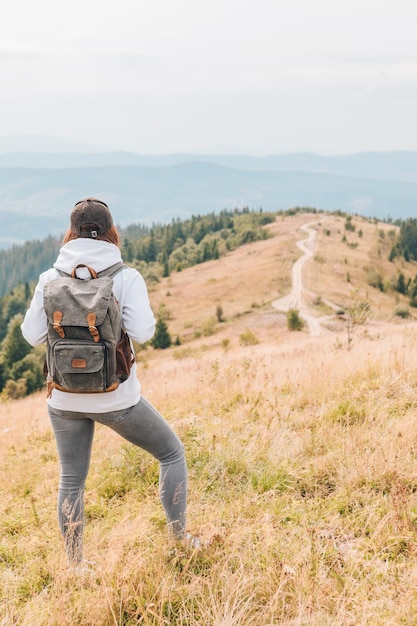 Hiking concept woman with backpack at mountains peak