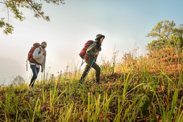 Hiking couple with backpack walking on mountain