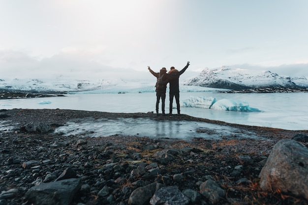 Hiking on a glacier in Iceland, breathtaking view, traveler stands on stone, Travelers have reached their destination, friendship