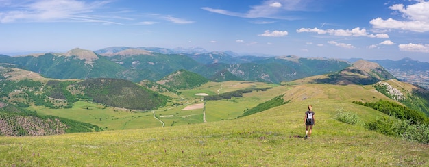 Hiking in the Montelago highlands Marche Italy Woman walking in green landscape unique hills and mountains landscape Summer outdoors activity