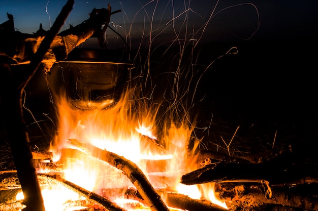 Hiking in nature at sunset preparing for a hike at the stake put out the fire outdoors romance of wi...