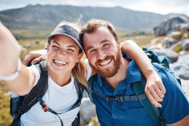 Hiking selfie and love with a couple in the mountains for fitness exercise or adventure together Portrait nature and bonding with a man and woman walking outdoor on a natural mountain trail