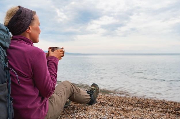 Hiking tourism adventure backpacker woman resting after hiking looking at beautiful view hiker girl