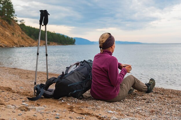 Hiking tourism adventure backpacker woman resting after hiking looking at beautiful view hiker girl