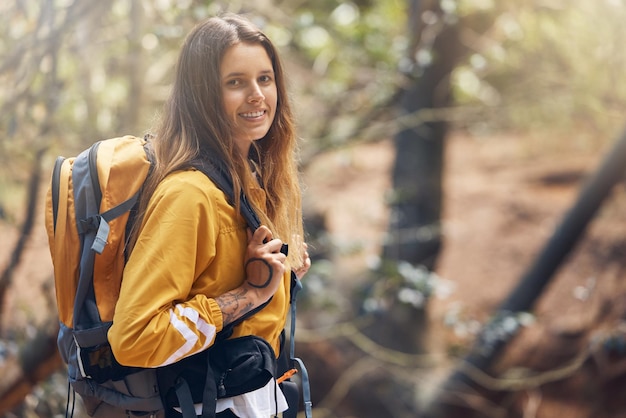 Photo hiking woman and portrait in forest for adventure backpacking and nature backpacker smile and exercise for fitness explore environment and hobby in countryside woods for travel holiday vacation