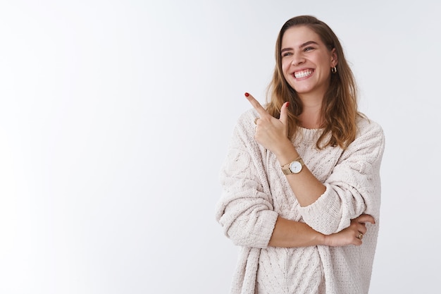 Hilarious scene woman cannot stop laugh. Carefree attractive joyful charming girl turning sideways pointing left corner smiling amused having fun watching funny tv series, standing white background