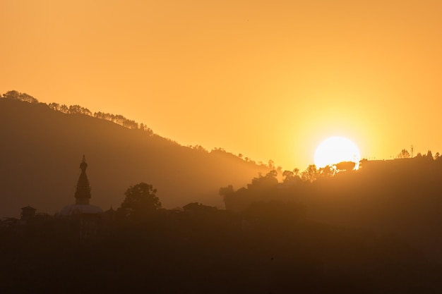 Hills with trees and buddhist temple at sunset. Asia