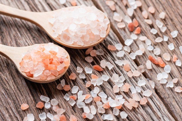 Himalayan pink salt crystals with white salt on wooden spoon