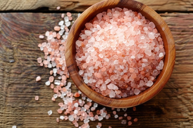 Himalayan pink salt in a wooden bowl on rustic wood background highlighting natural and culinary themes Pink Himalayan salt in a bowl rustic and culinary appeal